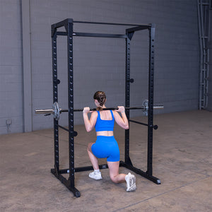 Woman doing a barbell split squat inside the black Best Fitness BFPR100B power rack