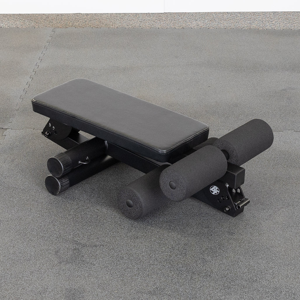Best Fitness BFAB10B AB Folding Bench set up on the gym floor, rear three-quarter view showing the foam foot rollers