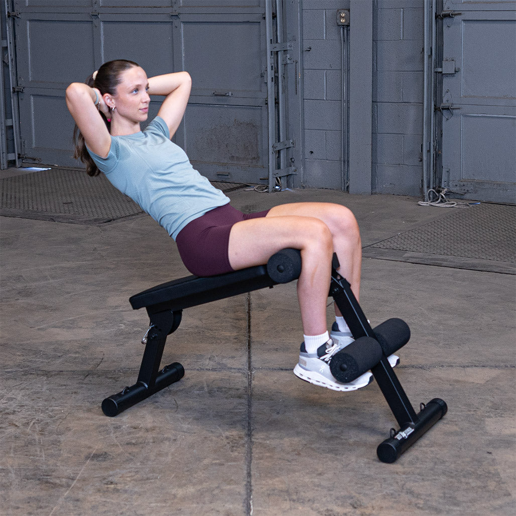 Best Fitness BFAB10B AB Folding Bench — decline sit-up at the top of the rep, feet secured under the foam rollers