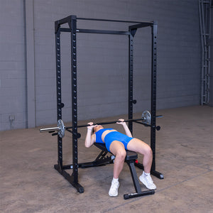Man doing a flat barbell bench press inside the black Best Fitness BFPR100B power rack